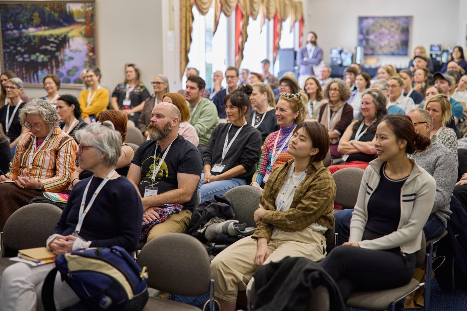 Conference plenary session with participants seated and listening