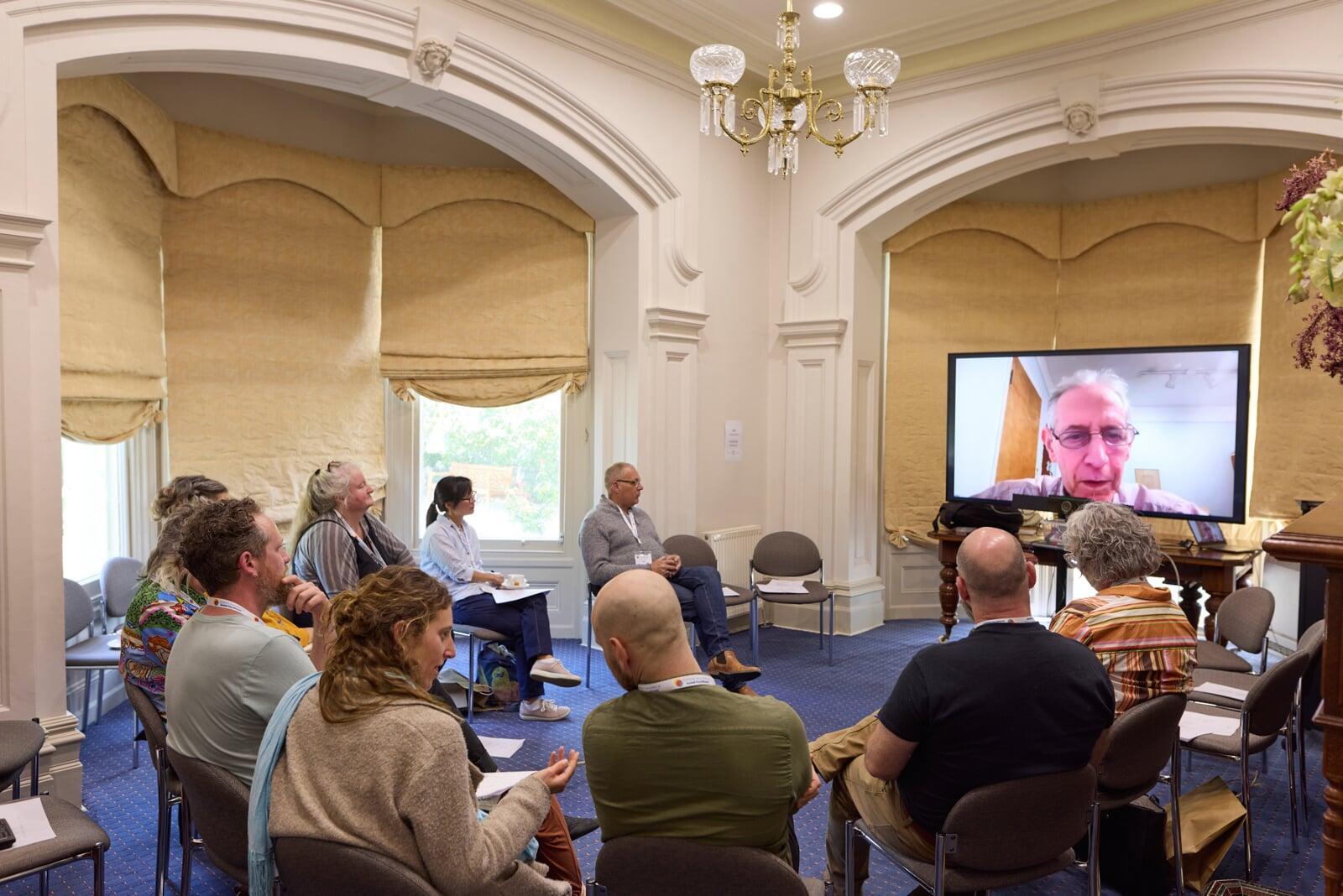 Online presenter speaking via video link during conference session
